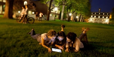 Students sharing a tablet computer on the UNR quad
